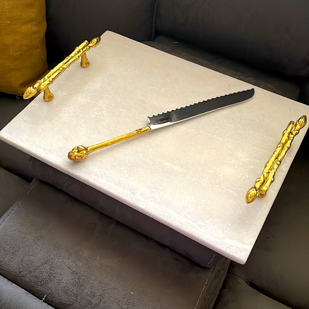 White marble challah tray with gold handles.